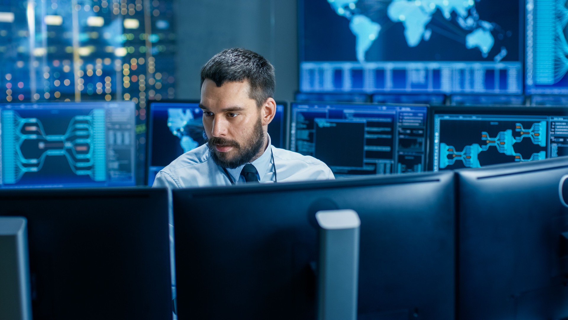 En el trabajo de operador de centro de Control de sistema rodeado de pantallas que muestran los datos pertinentes. En los datos de fondo con mapa interactivo.