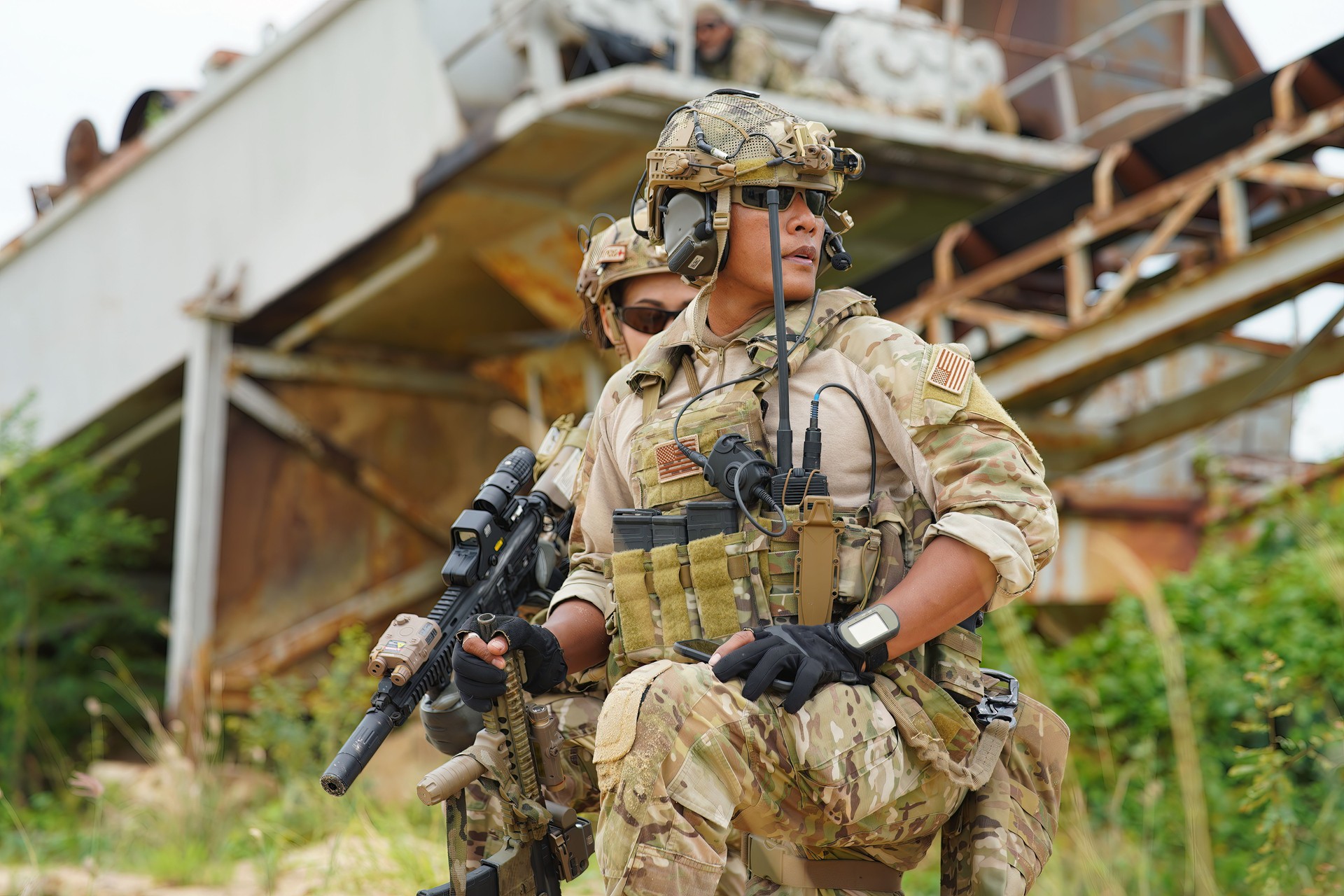 soldier in the battle field sitting knee down on the ground hold the gun alert look around